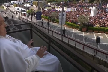 Pope Francis waves to the gathered faithful from the balcony at Gemelli Hospital in Rome on Sunday, March 23, 2025